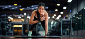 Happy beautiful young asian woman doing push ups exercise with o