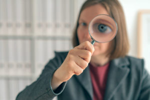 Businesswoman with magnifying glass doing business financial aud